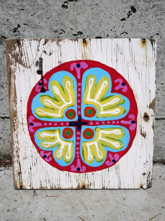 Folk art mandala painted on a whitewashed wood board by Lone Peep: red, blue, yellow and pink circular flower motif.