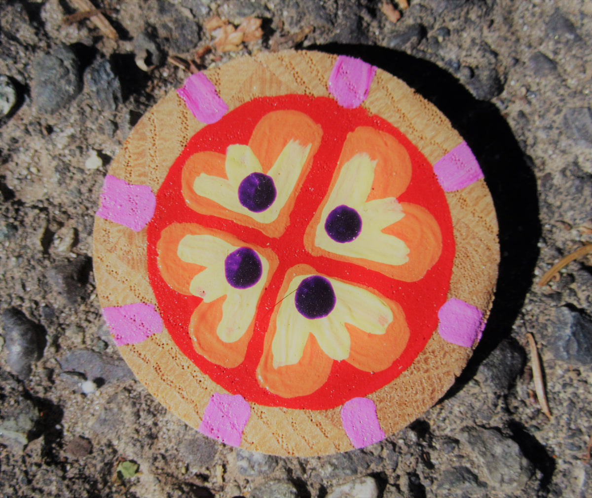 Painted wood slice by Lone Peep: red and yellow flower with purple dots and pink edge dashes.